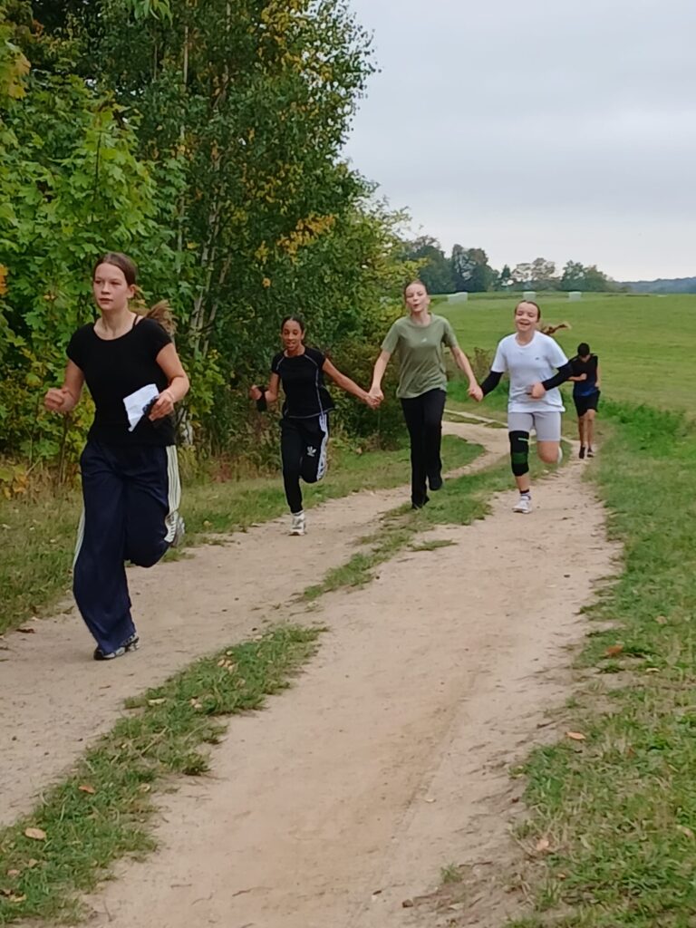 Schüler:innen des FJG laufen einen Feldweg entlang.