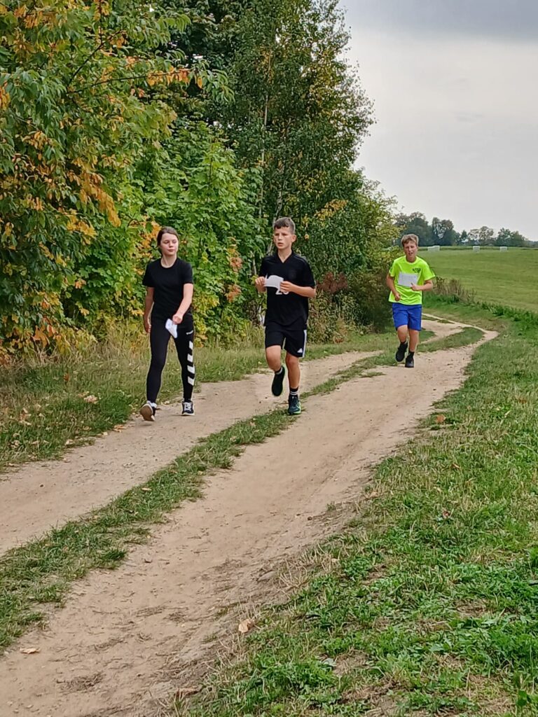 Schüler:innen des FJG laufen einen Feldweg entlang.
